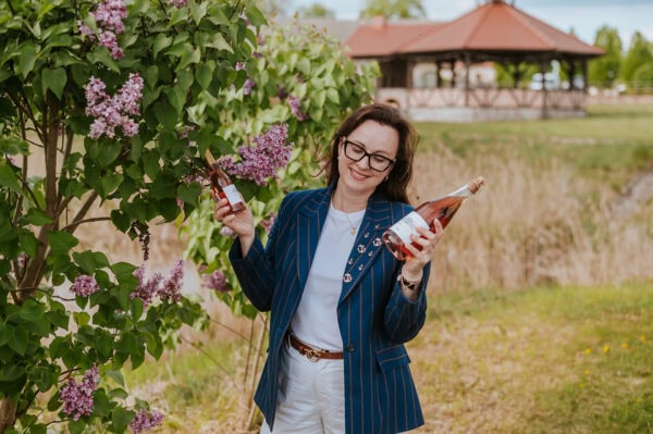 Wino różowe z lubuskiej winnicy Kobieta z dwoma butelkami różowego wina w winnicy lubuskiej.